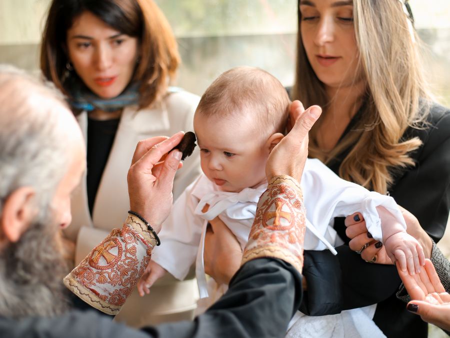 A baby being blessed at a christening ceremony
